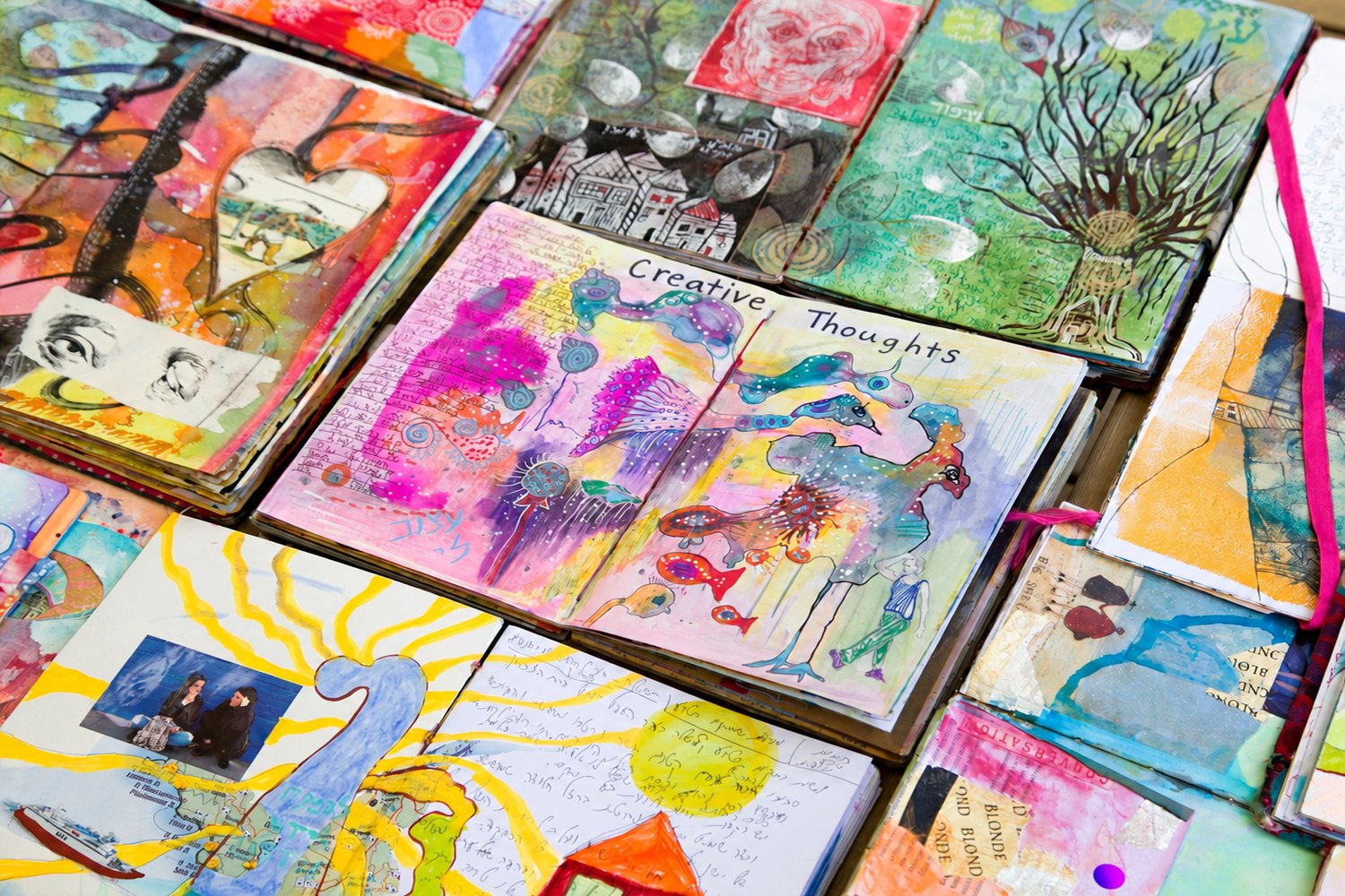 A wall of finished SoulPages journals, every spread different