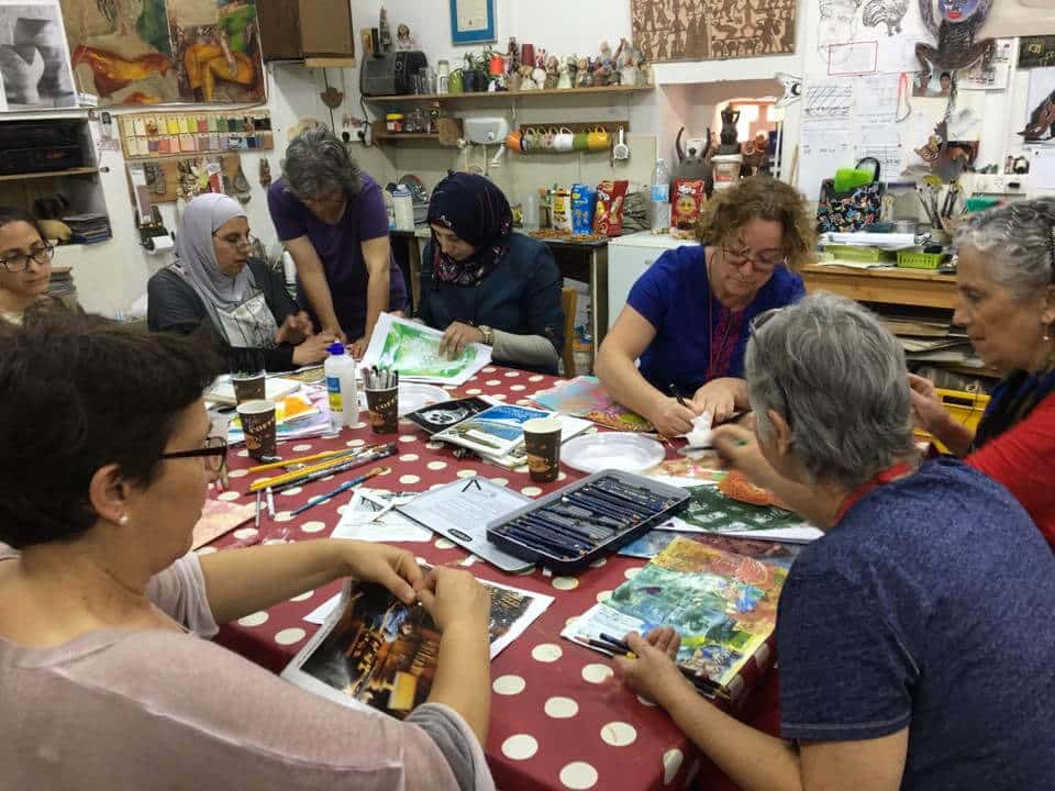 A journaling group around one table, each woman working on her own page